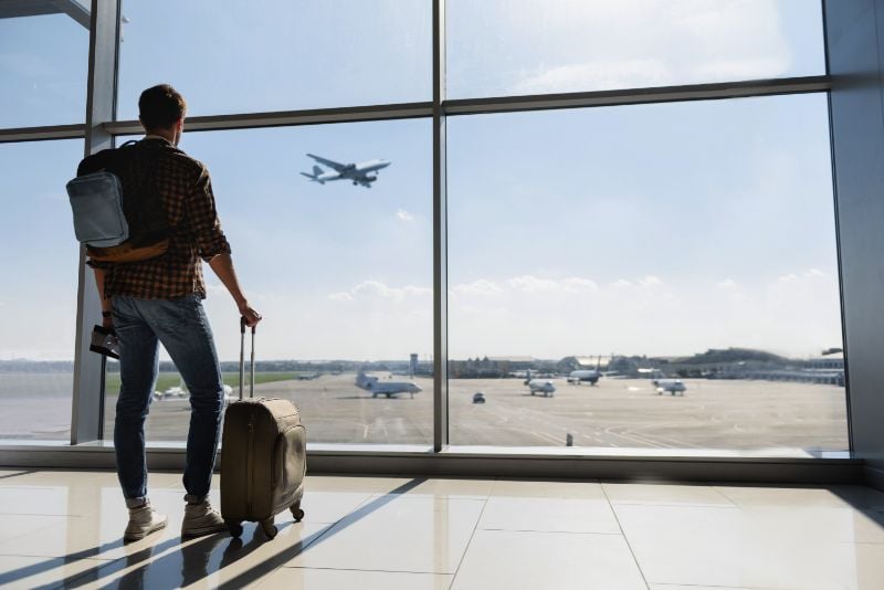 Male traveler with a backpack and hand luggage