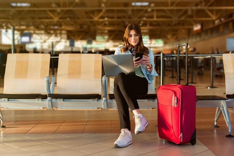 Young female traveler in airport terminal hall