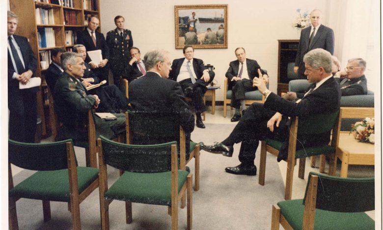 President Clinton in a meeting sitting in a circle with Ambassador Christopher R. Hill and others