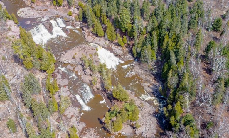 Aerial photograph of Gooseberry Falls with cascading water, evergreen trees, and visitors at the park, illustrating Minnesota's scenic landscapes.