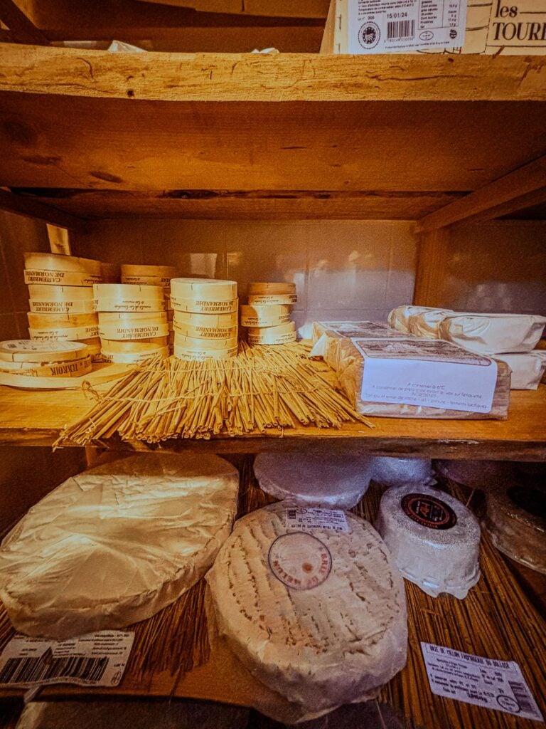 Artisanal cheese ripening process in traditional Parisian fromagerie, with a variety of carefully matured cheeses on wooden planks.