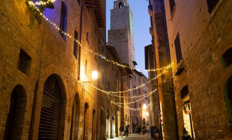 Twilight over cobblestoned San Gimignano, medieval towers rising against the Italian sky