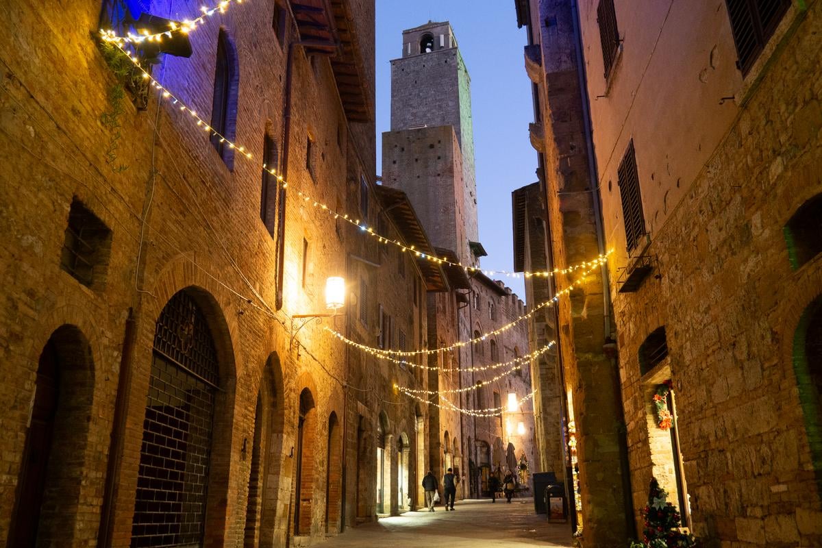 Twilight over cobbled San Gimignano, medieval towers rising against the Italian sky