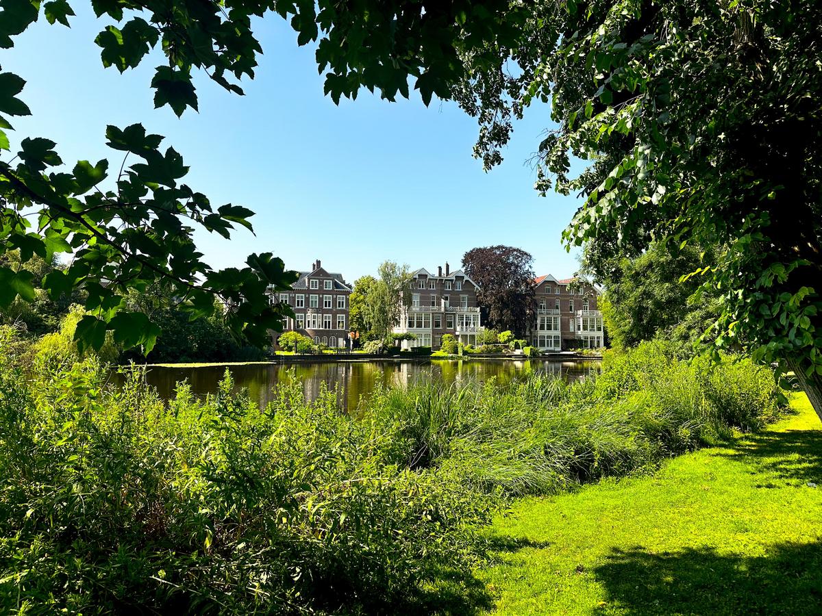 Vondelpark landscape with green, calm water and Dutch architecture