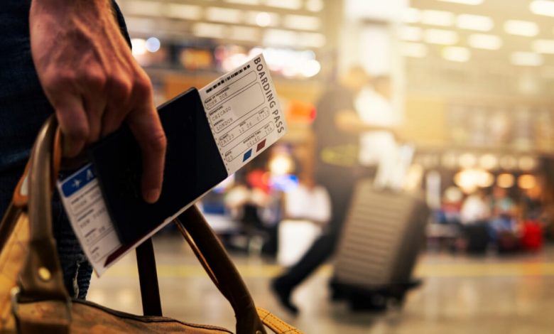 Holding a passport and boarding pass in a crowded airport